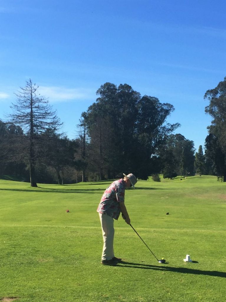 golfer teeing off